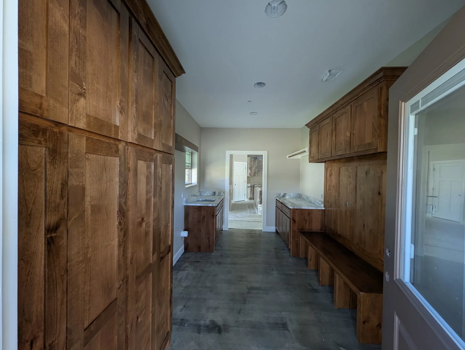 Mudroom lined with dark wood-tone cabinets and a built-in bench